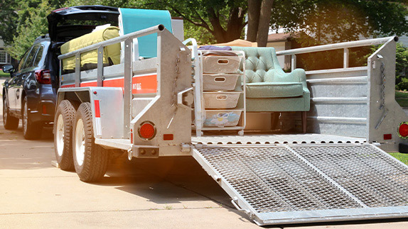 SUV with trailer hauling furniture